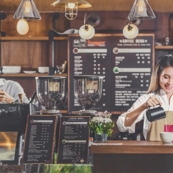 Asian Barista preparing cup of coffee, espresso with latte or cappuccino for customer order in coffee shop,bartender pouring milk,Small business owner and startup in coffee shop and restaurant concept