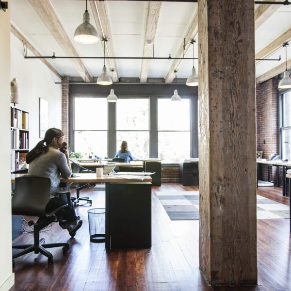 Asian woman and HIspanic man working at their desks in a creative office.