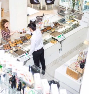 Waiter serving customer in a pastry shop, view from above - Woman buying cake and cookies for breakfast