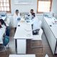 Education, science and students in lab classroom with professor and equipment for test. Technology,.