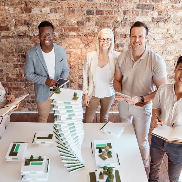 Group of diverse architects discussing plans, blueprints and schematics during a meeting in their o.