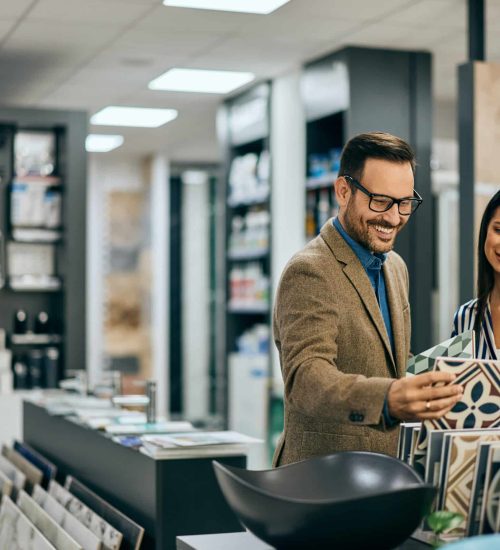 Two happy professionals discussing home decor options in a stylish showroom setting